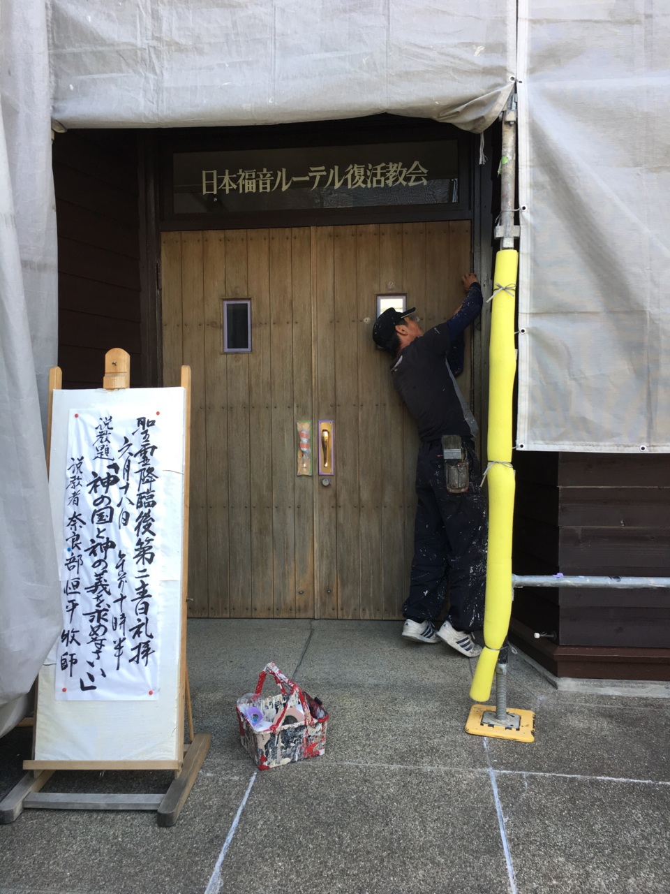 玄関の扉を塗るため、養生をする川脇さん！